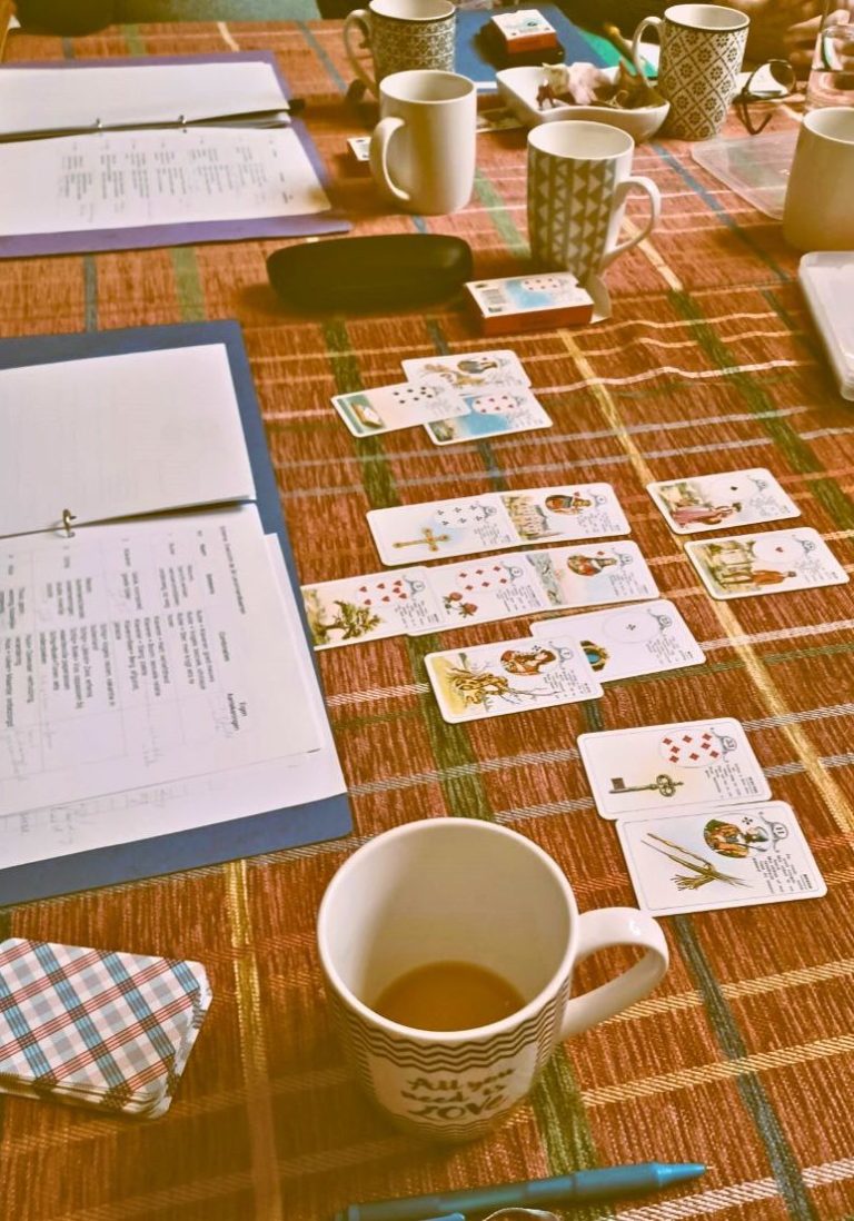 Workshop kaartleggen – praktijk, studie en ontmoeting Studietafel met kaarten en een koffiekop op een tafel met een ruitpatroon.